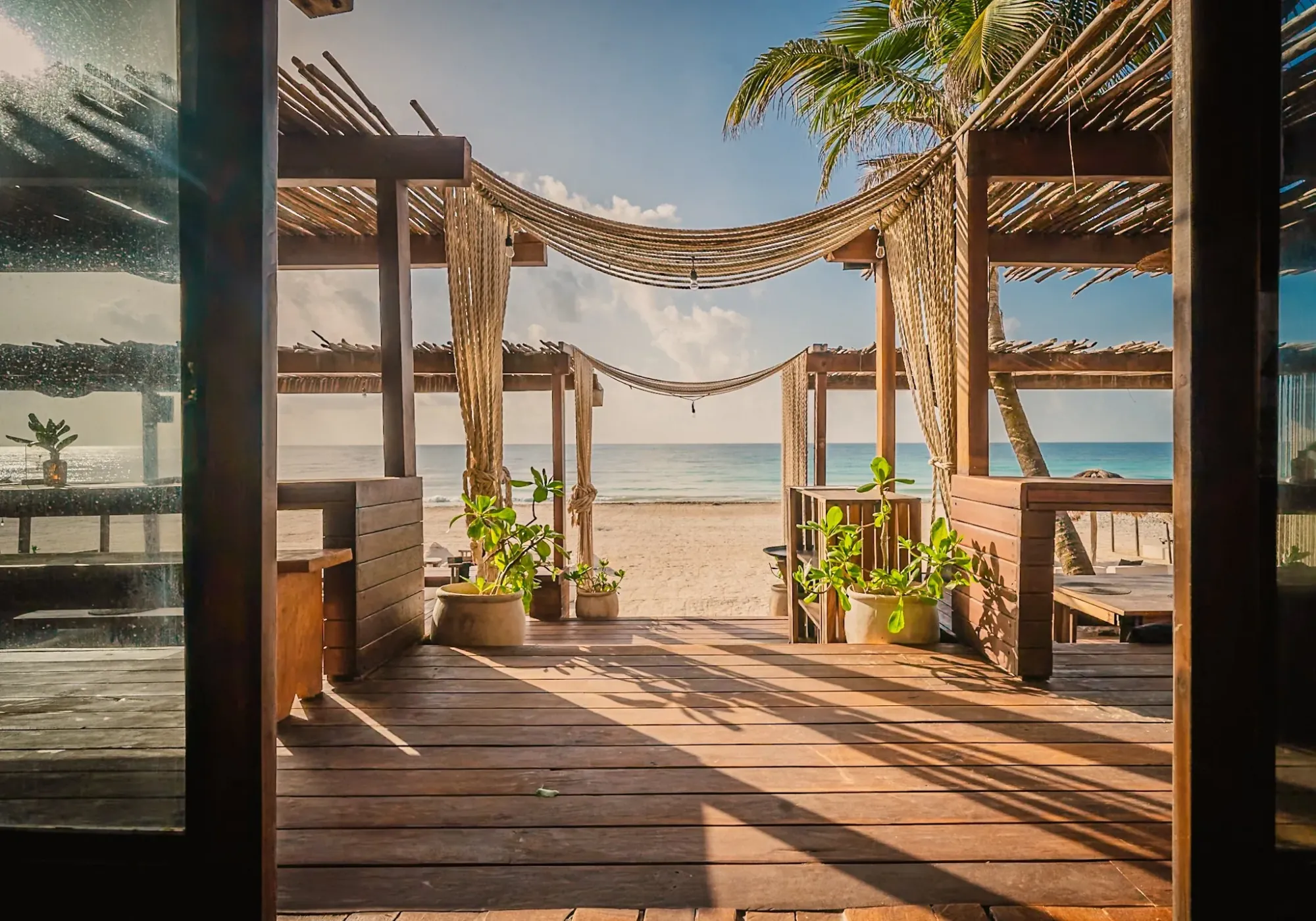 Tulum beach club with wooden palapa structure overlooking turquoise Caribbean ocean