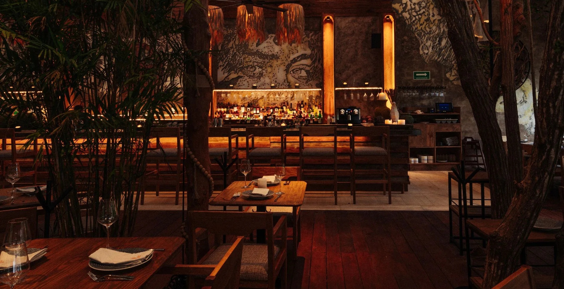 Upscale Tulum restaurant with warm ambient lighting and tropical decor